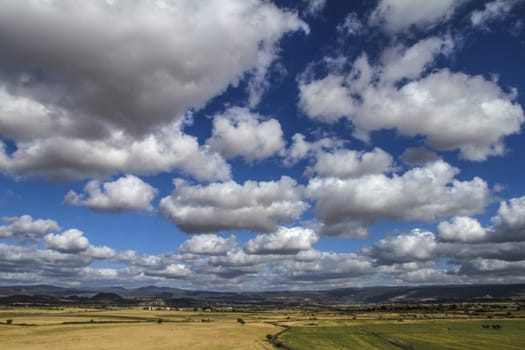 Clear sky with natural colors of an intense Mediterranean blue and white clouds on a plain of typical Sardinian vegetation