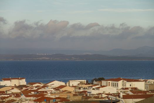 View of the roofs of a country in Sardinia with a varied sky in layers that generates a pleasant visual effect