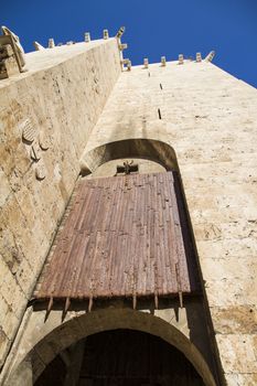 Ancient wooden rolling shutter gate with metal reinforcements at the entrance to the historical center of Cagliari in Italy