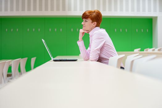 Young beautiful woman on a university lecture working on a white laptop