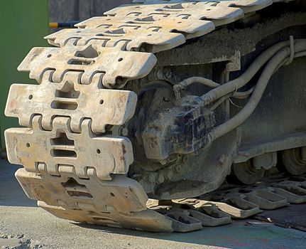 The massive tracks of a large earth-moving equipment
