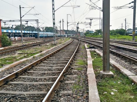 Close Up of Indian Railway Tracks low angel view from a rails sleepers near railway station platform during day time in Howrah Station car shed area. Kolkata India South Asia Pacific March 18, 2020