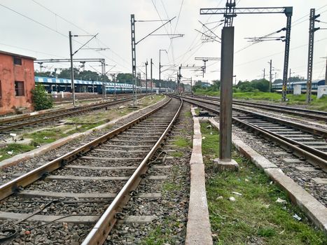 Close Up of Indian Railway Tracks low angel view from a rails sleepers near railway station platform during day time in Howrah Station car shed area. Kolkata India South Asia Pacific March 18, 2020