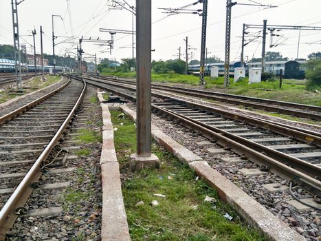 Close Up of Indian Railway Tracks low angel view from a rails sleepers near railway station platform during day time in Howrah Station car shed area. Kolkata India South Asia Pacific March 18, 2020