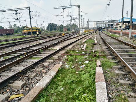 Close Up of Indian Railway Tracks low angel view from a rails sleepers near railway station platform during day time in Howrah Station car shed area. Kolkata India South Asia Pacific March 18, 2020