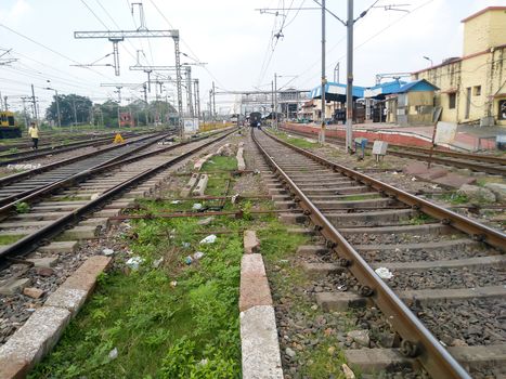 Close Up of Indian Railway Tracks low angel view from a rails sleepers near railway station platform during day time in Howrah Station car shed area. Kolkata India South Asia Pacific March 18, 2020