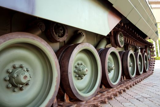 Linked metal plates and wheels of the tracks belonging to an armored vehicle
