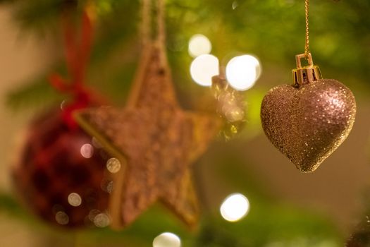 A glittery heart shaped Christmas Tree Decoration hanging from a tree