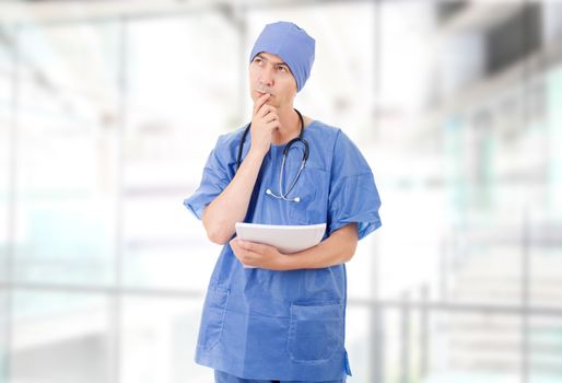 worried doctor looking to his notes, at the hospital