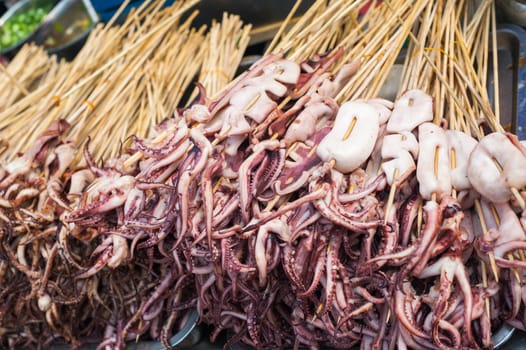 Squid skewers heap in a street market in Luodai, Chengdu, Sichuan province, China