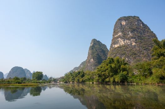 Lake with limestone karst hills foggy landscape reflecting in the river in Yangshuo, Guangxi province, China