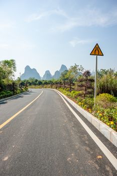 Empty road with karst hills in the background in Yangshuo, Guilin, Guangxi province, China
