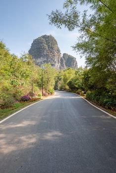 Empty road with karst hills in the background in Yangshuo, Guilin, Guangxi province, China