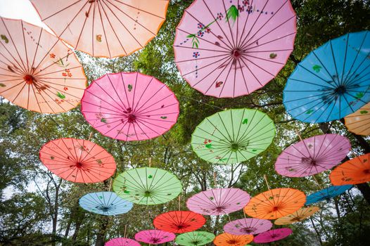 Chinese traditional multicolored umbrellas hanged on trees low angle view in Guilin, Guangxi province, China