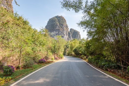 Empty road with karst hills in the background in Yangshuo, Guilin, Guangxi province, China