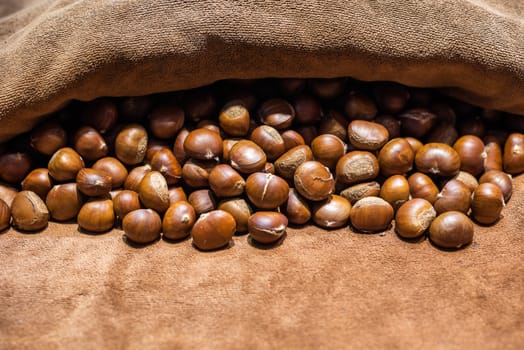 Roasted Chestnuts on brown towel close up view.