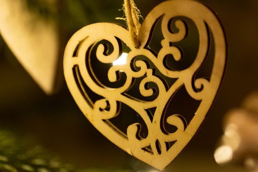 A wooden heart shaped Christmas Tree Decoration hanging from a tree