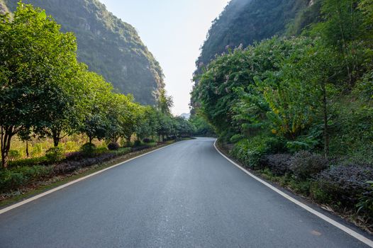 Empty road with karst hills in the background in Yangshuo, Guilin, Guangxi province, China