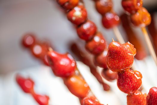 Tanghulu traditional Chinese hard caramel coated strawberry skewers close-up also called bing tanghulu candied hawthorn sticks