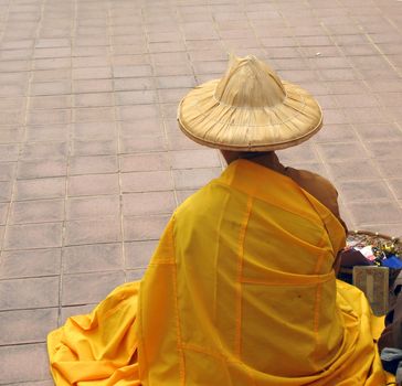 -- in yellow robe, begging for alms and selling trinkets