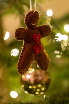 A fabric gingerbread man woman bear shaped Christmas Tree Decoration hanging from a tree