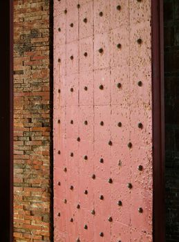 -- this door with large bronze nails guards the entrance to an old fort