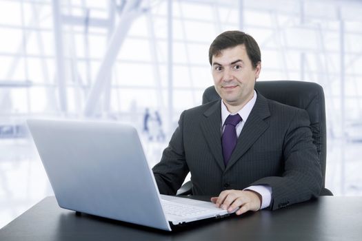 happy businessman working with is laptop, at the office