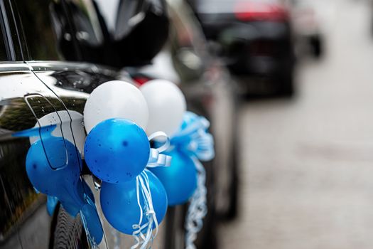 car with blue and white balloons to bring newborn baby home from maternity hospital - image