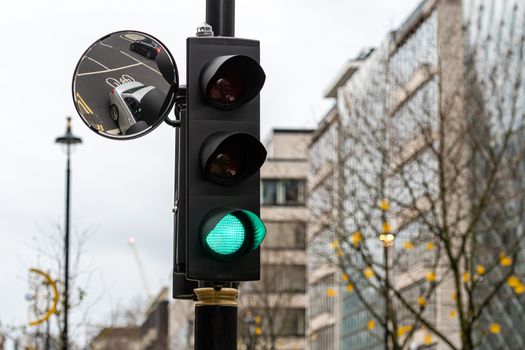 Green Traffic Light Signal and Traffic Convex Mirror with the Reflection of the vehicle