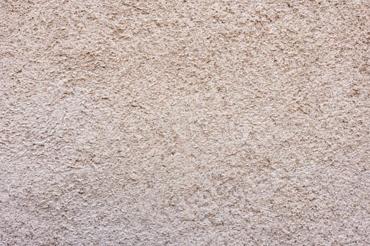 Close-up of a texture fragment of a decorative wall plaster on a building wall - image