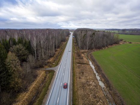 aerial view from above of country road through the forest in spring morning, drone photography
