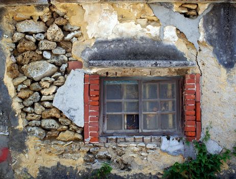 An old house with walls made from rocks with wood frame window