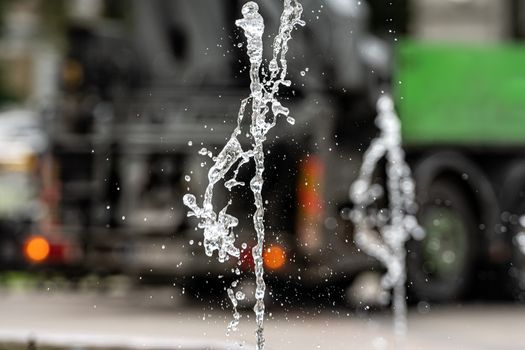 water fountain splashes on blurred street background