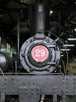 An old steam powered locomotive with a large boiler and chimney
