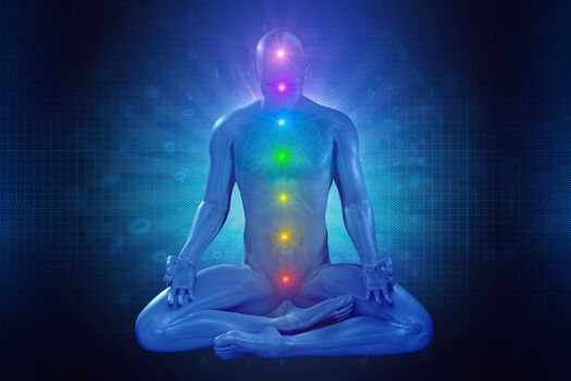 man meditating with seven colorful chakras