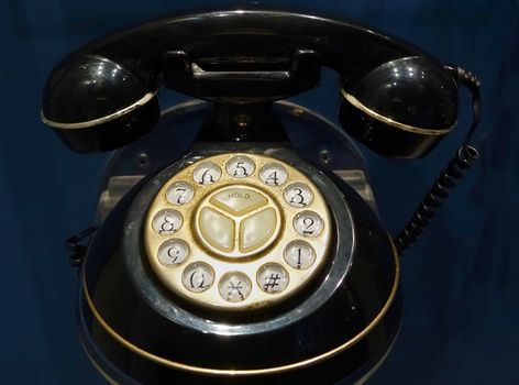 An old rotary dial telephone with black handset