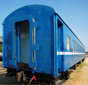 A vintage train carriage that has been freshly painted in bright blue
