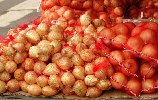 Large sacks of onions are sold at an outdoor market