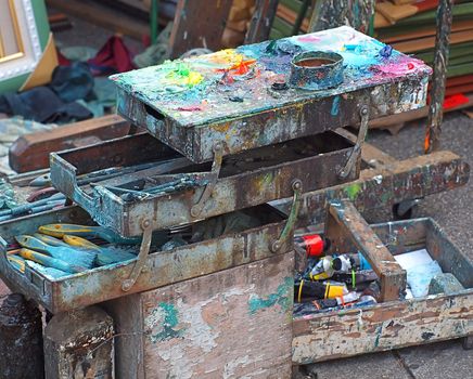 Trays with paints and brushes and a color mixing area of an outdor painter