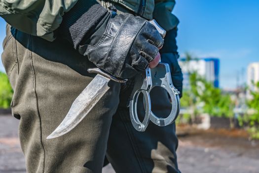 Handcuffs in the hands of a policeman close-up. Part of police equipment
