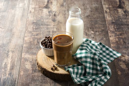 Iced coffee or caffe latte in tall glass on wooden table