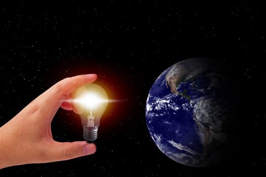 Energy concept, hand and light bulb on space background, nature and ecology, Elements of this image furnished by NASA