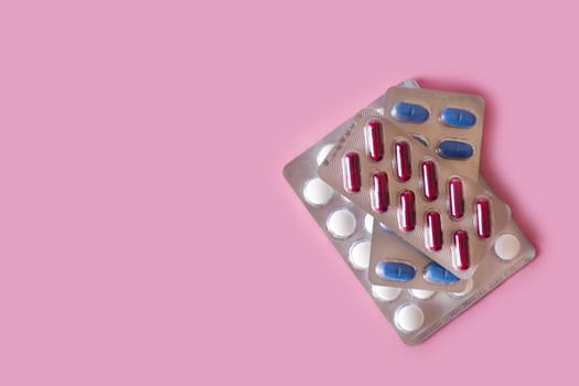 Medical pills on pink background