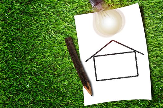 Green energy concept, drawing house and light bulb on grass background, nature and ecology