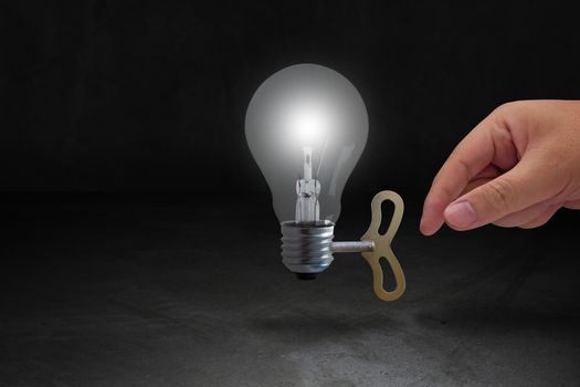 Power and energy concept, hand and light bulb on dark background, nature and ecology