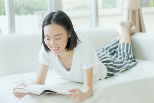 Woman reading a book on a sofa