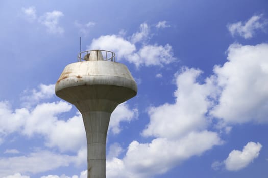 Water tower with clouds and blue sky background.
