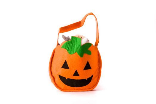 Halloween pumpkin bag with candies inside isolated on white background