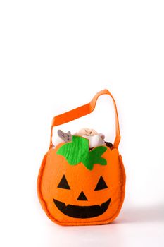 Halloween pumpkin bag with candies inside isolated on white background