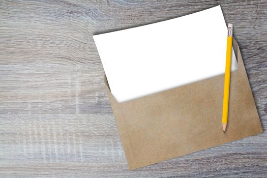 Opening business envelope, blank white paper and yellow pencil on wood background